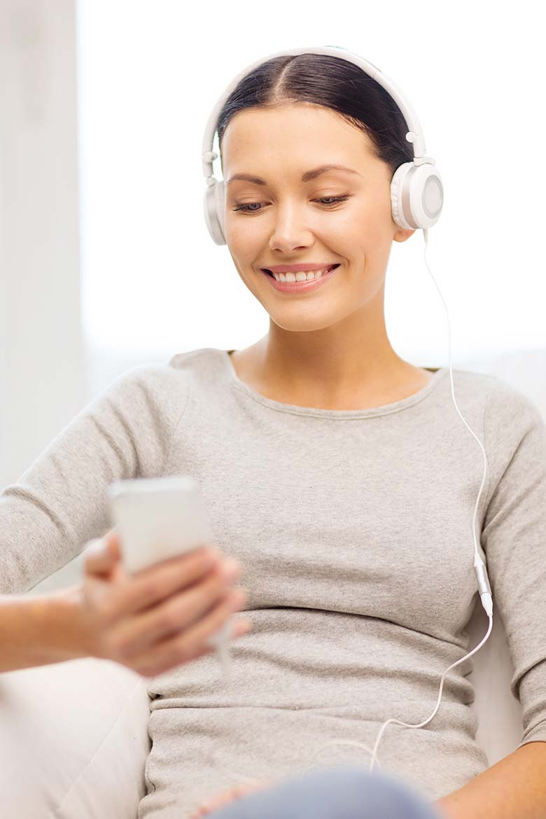 A woman with headsets plugged into her mobile device and doing a video telehealth session